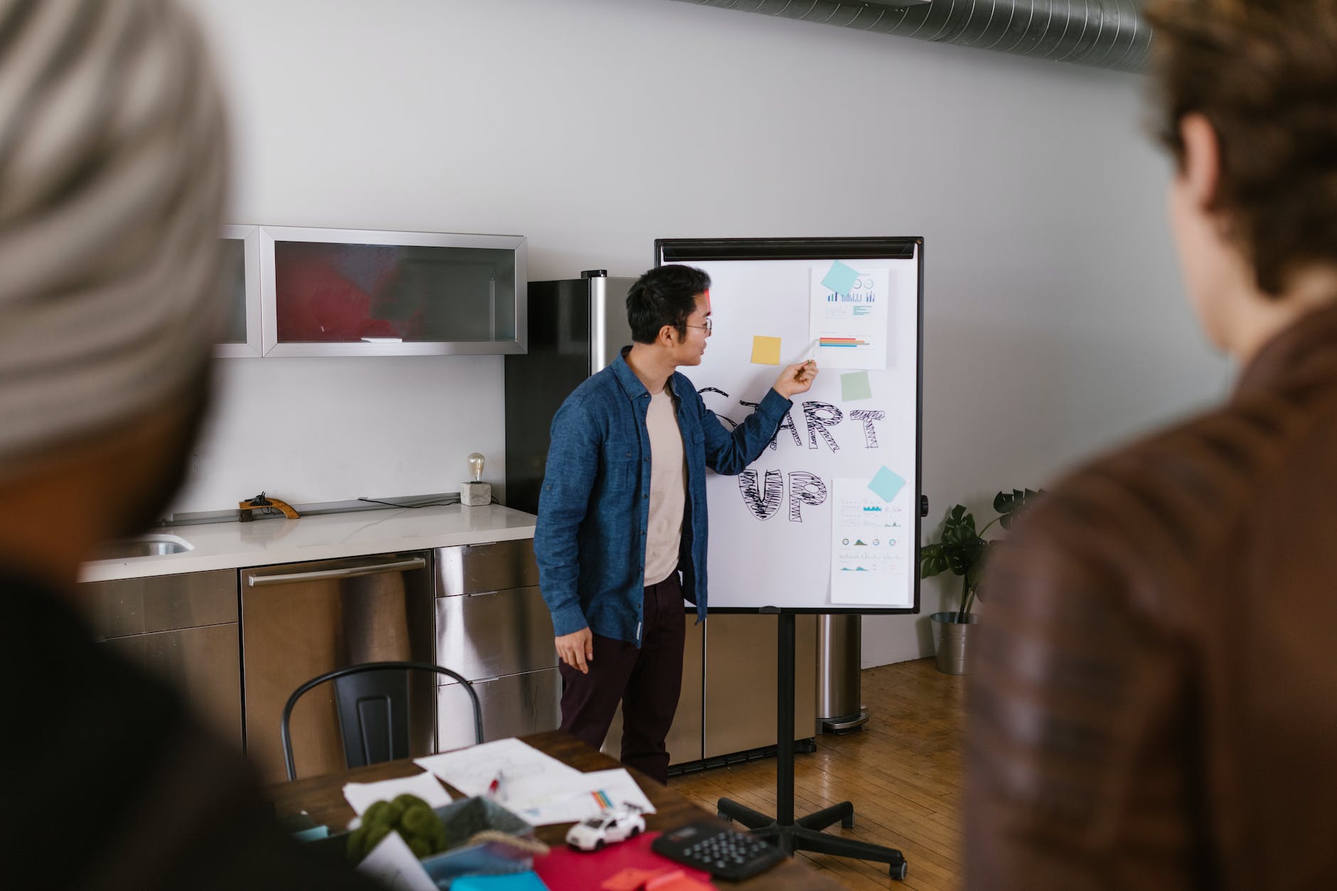 man in blue jacket looking at white board